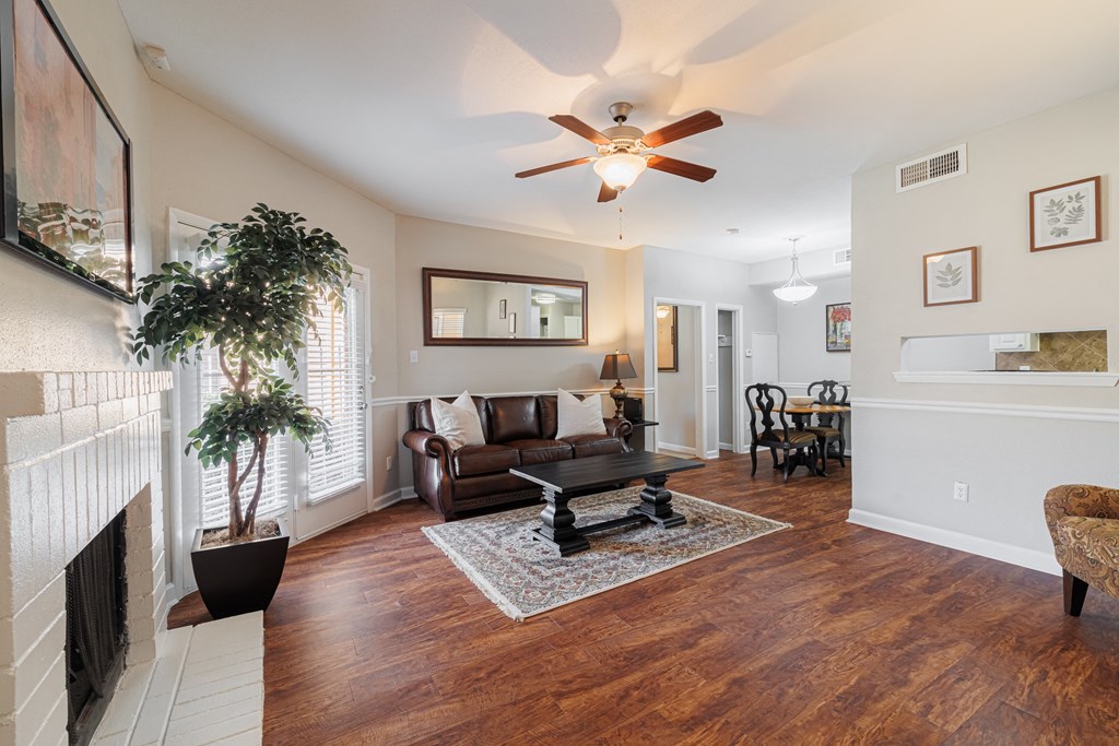 a living room with a ceiling fan and a fireplace