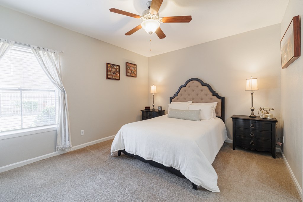 a bedroom with a bed and a ceiling fan