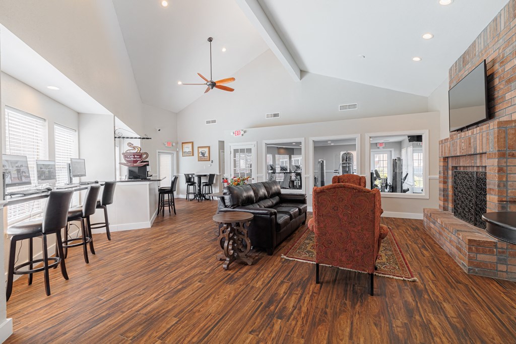 a living room with a fireplace and a leather couch    and a bar