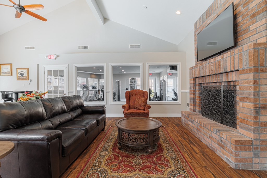 a living room with a leather couch and a fireplace