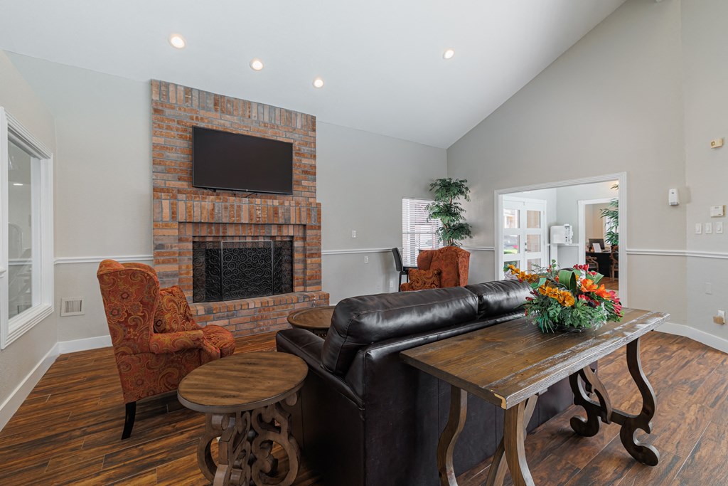 a living room with a leather couch and a table and a fireplace