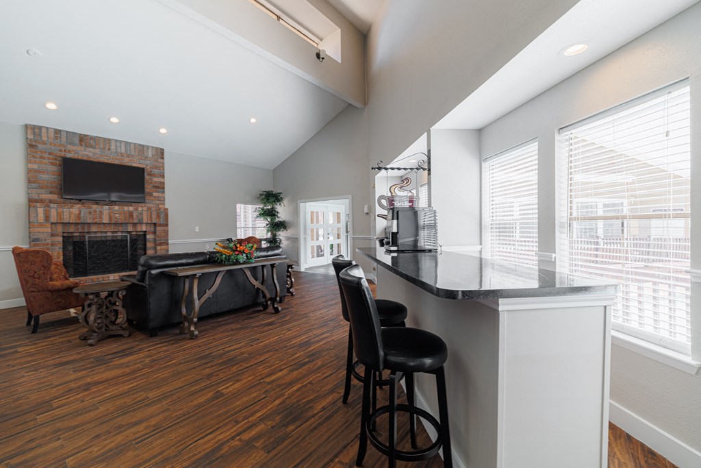a kitchen with a bar and a living room with a fireplace