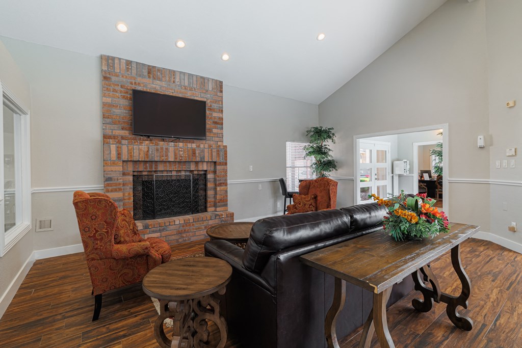a living room with a leather couch and a brick fireplace