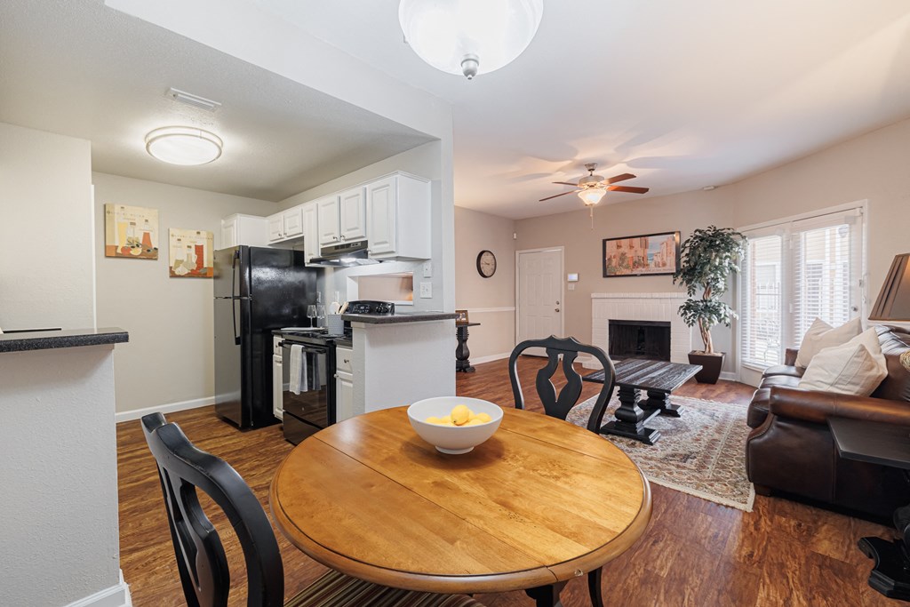 the view of a living room with a table and a kitchen