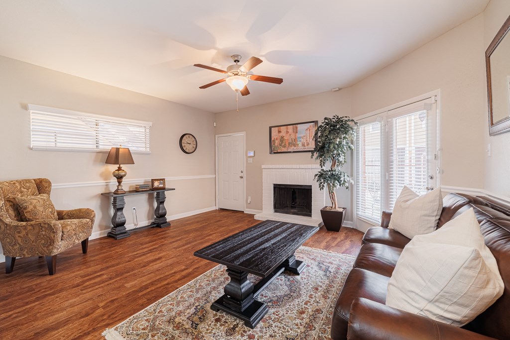a living room with a ceiling fan and a leather couch