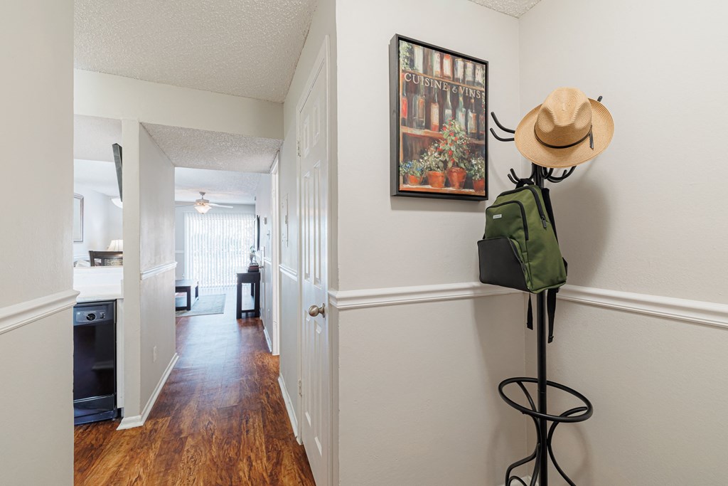 A cowboy hat is sitting on a stand next to a green backpack.