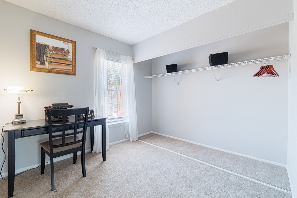 A room with a desk and chair in it.