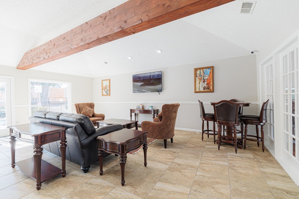 A living room with a couch, chairs, and a table.