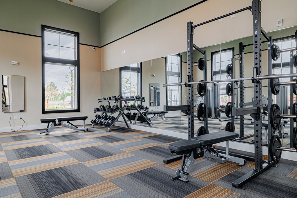 a fitness room with weights and other exercise equipment