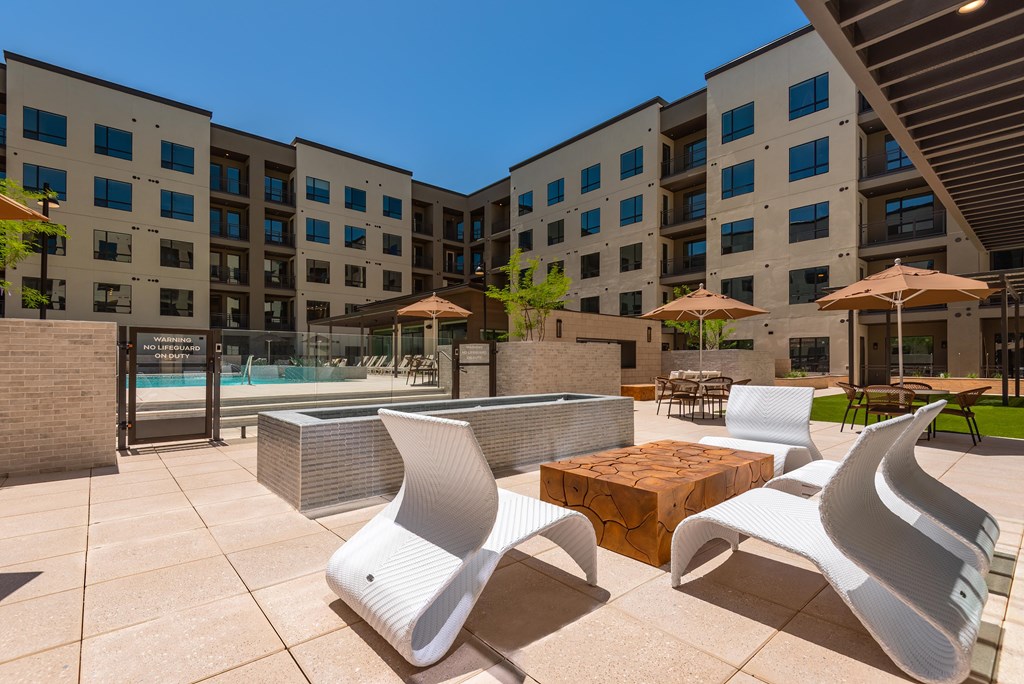 A modern outdoor seating area with white chairs and tables.