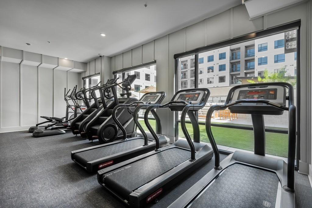 A gym with treadmills and elliptical machines.