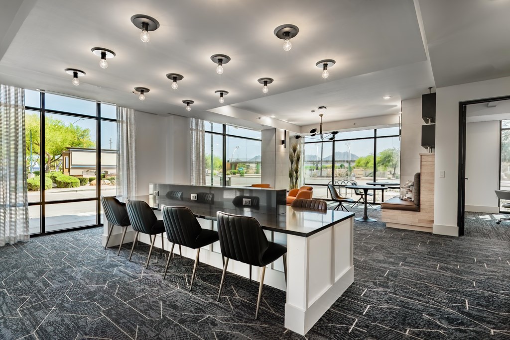A modern kitchen with black chairs and a black and white island.