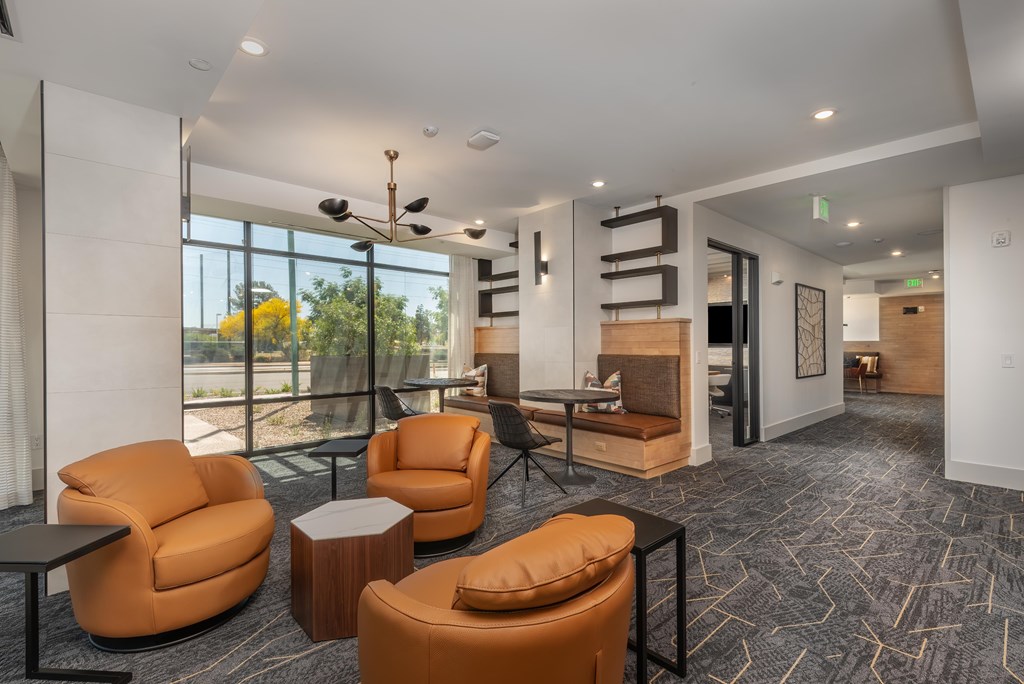 A room with orange chairs and a carpet with a grey pattern.