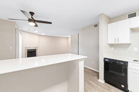 a kitchen with a white counter and a ceiling fan