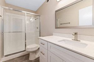 a bathroom with a toilet sink and shower