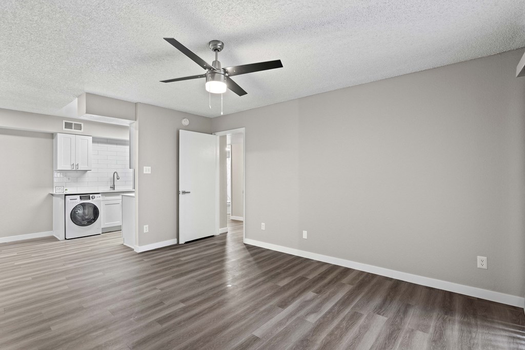 A room with a ceiling fan and a washer and dryer in it.