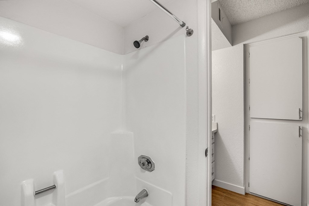 a bathroom with a white shower and a sliding glass door