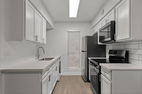 a kitchen with white cabinets and a black stove and refrigerator