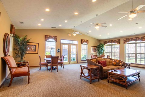 A living room with a brown carpet and wooden furniture.