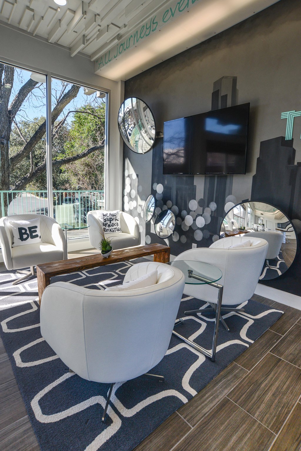 a living room with white furniture and a television