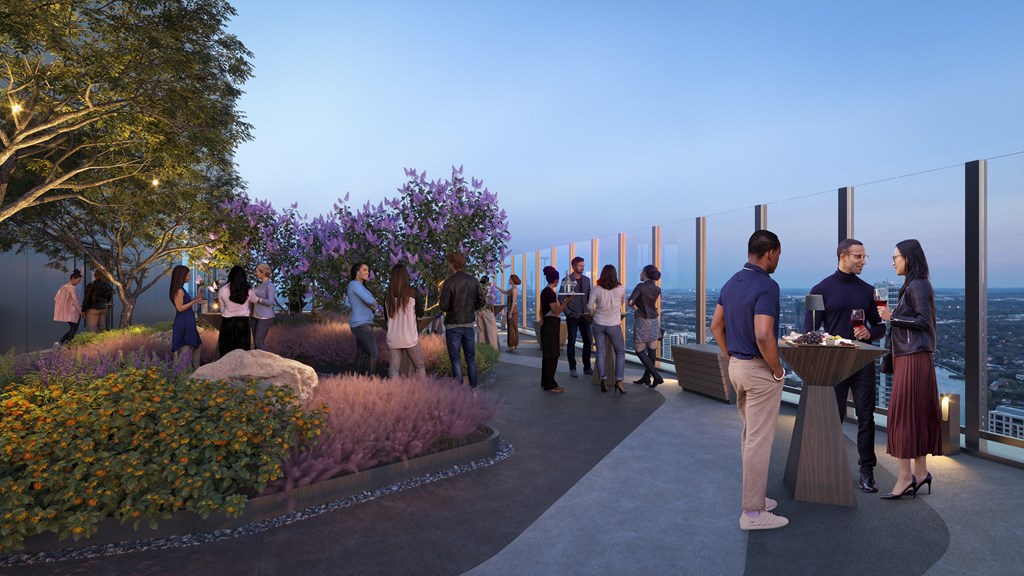 people eating and drinking on a terrace with a view of the city and sky