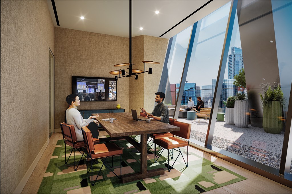 two people sitting at a table in a room with large windows