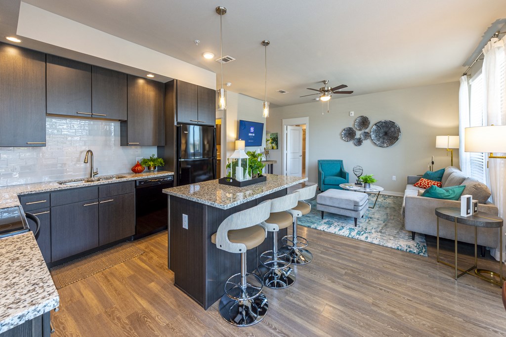 a kitchen with a bar and a living room with a couch