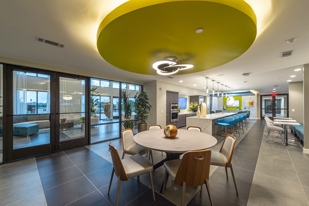a dining room with a table and chairs and a large yellow ceiling