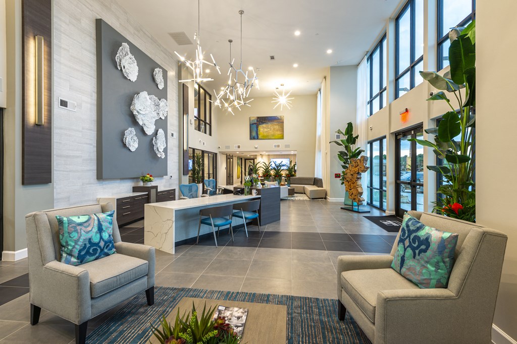 the lobby of a hotel with chairs and a table