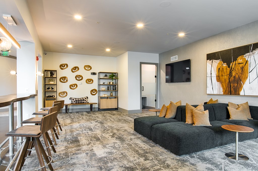 A modern living room with a grey sofa and a wooden coffee table.