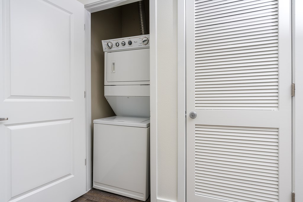 A white oven and dishwasher are installed in a kitchen cabinet.