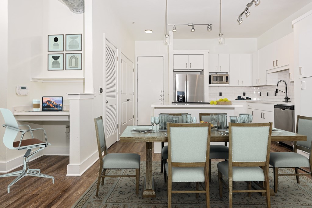 A kitchen with a table and chairs in front of it.