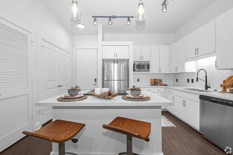 A kitchen with white cabinets and a wooden table.