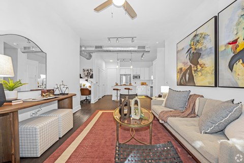 A living room with a couch, a coffee table, and a painting on the wall.