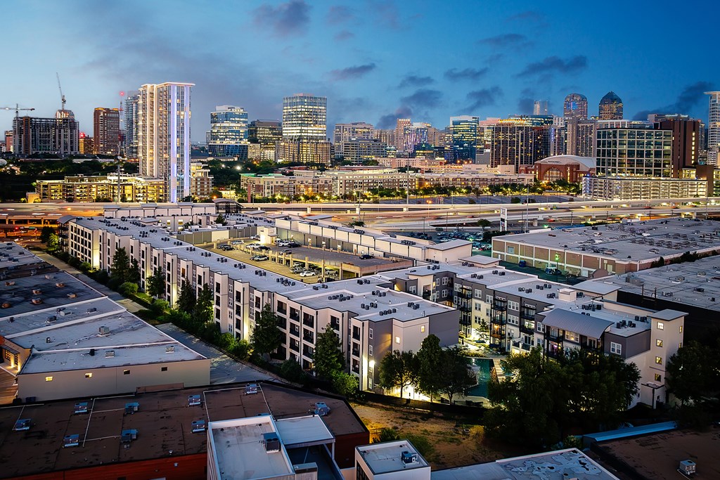 A cityscape at dusk with a mix of residential and commercial buildings.