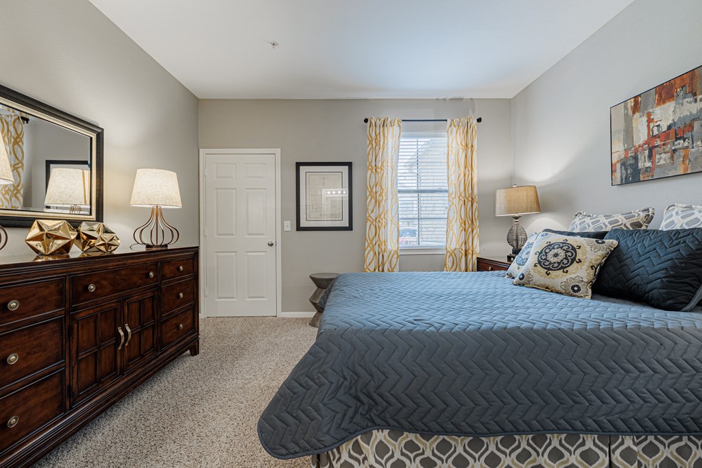 a bedroom with a bed and a dresser and a window