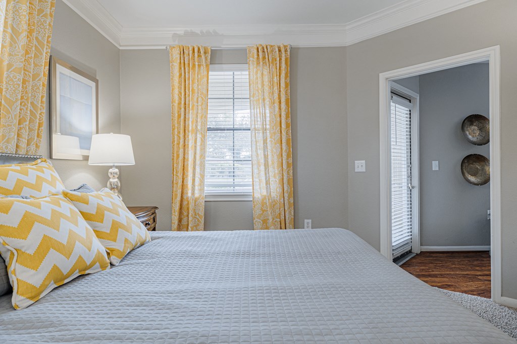 a bedroom with a large bed and yellow curtains