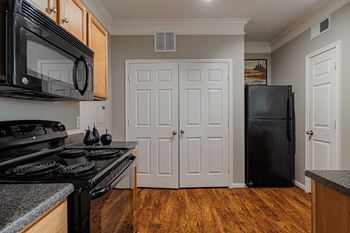 a kitchen with a stove and a refrigerator and a door