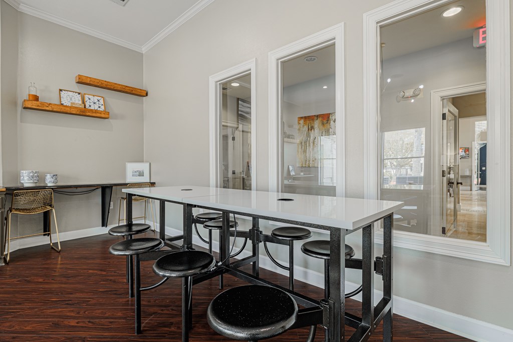 A dining room with a white table and black stools.