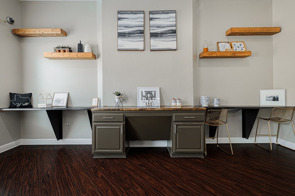 A room with a desk and chairs with a grey and black theme.
