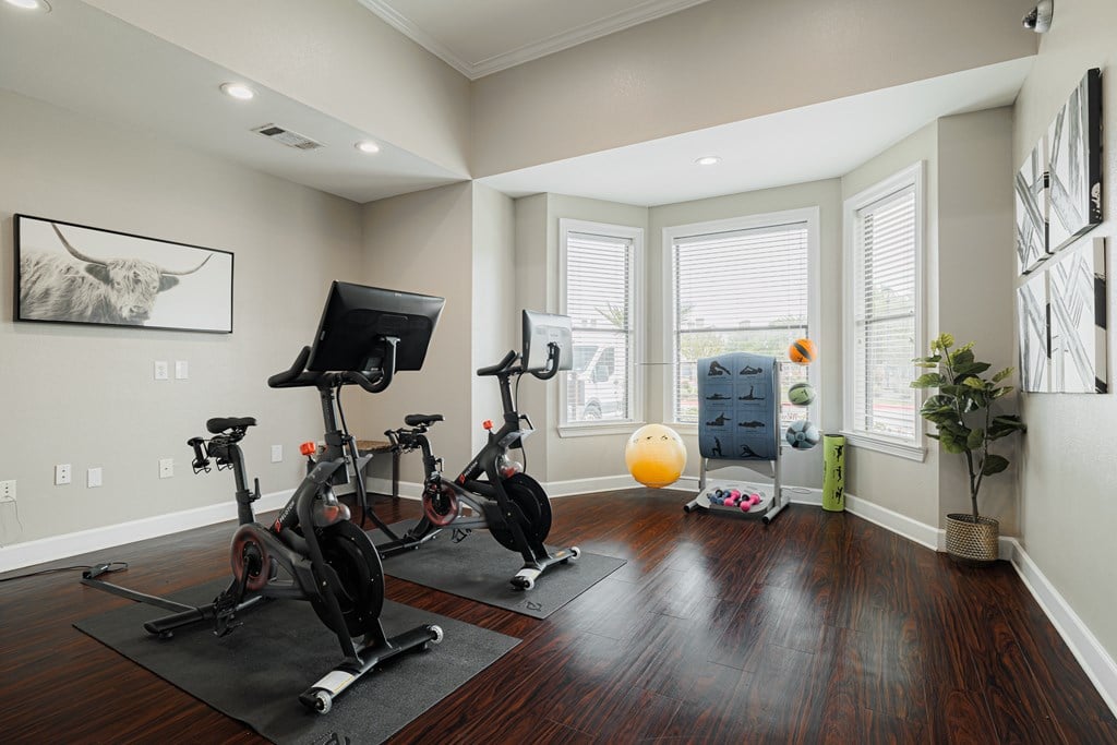 A room with a wooden floor and exercise equipment.