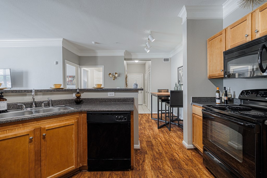 a kitchen with an island and a stove top oven and a sink