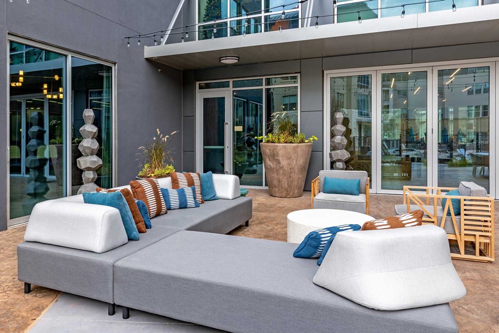 a seating area with couches and chairs in front of a building