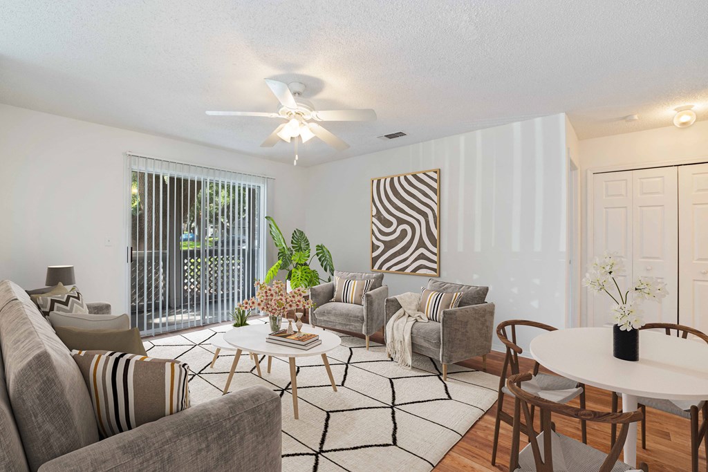 a living room with white walls and a white ceiling fan