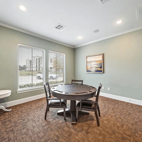 A dining room with a round table and chairs.