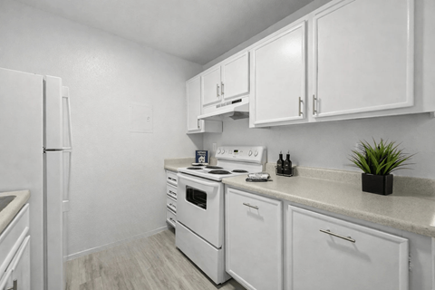 A kitchen with white appliances and cabinets.