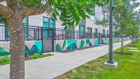 a sidewalk with a mural on the side of a building