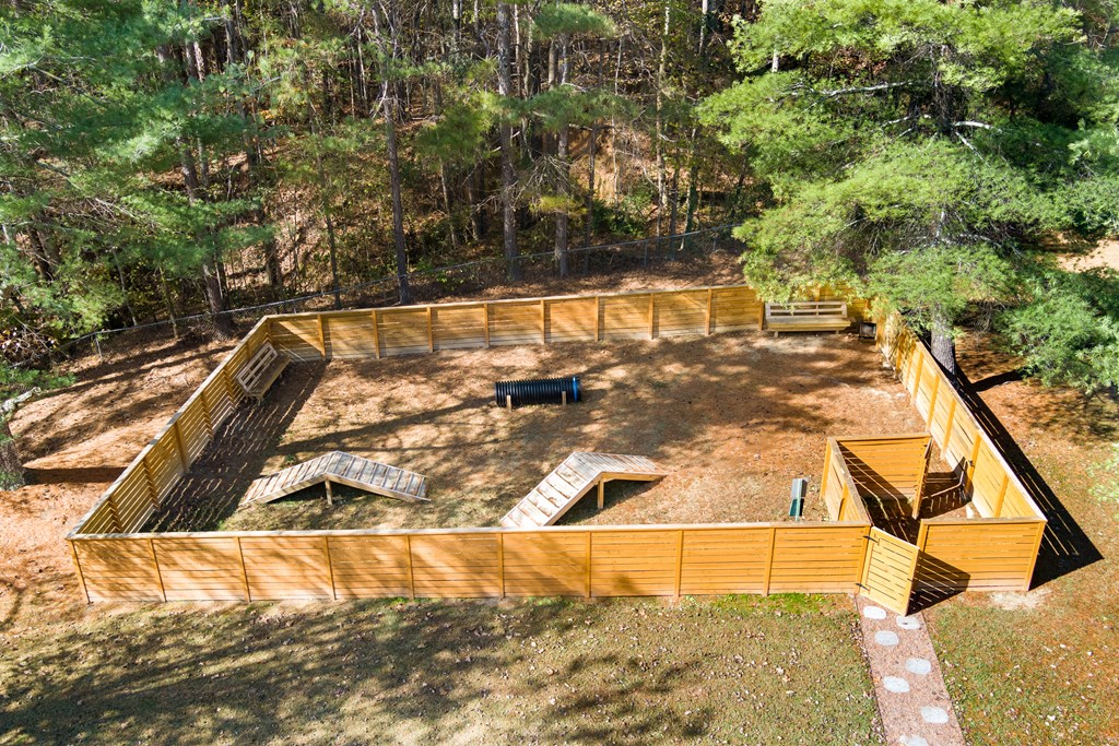 a large fenced in area with trees in the background