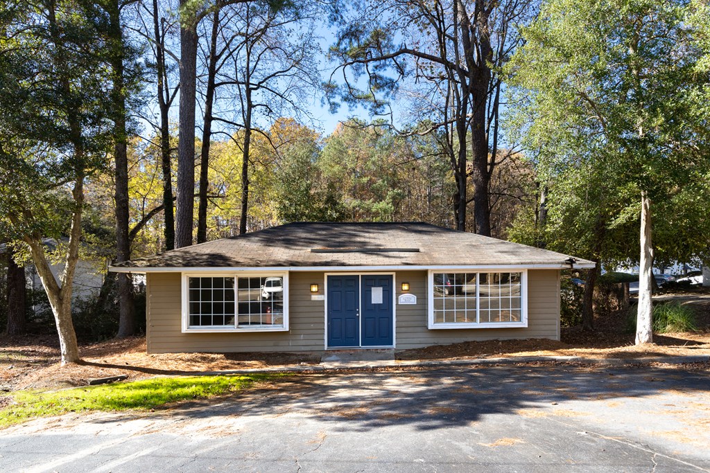 a house with a blue door and windows in a wooded area