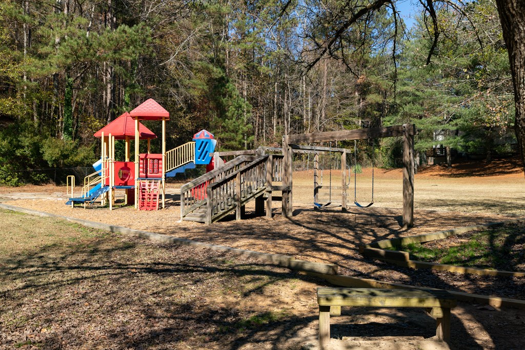 a playground in a park with trees in the background